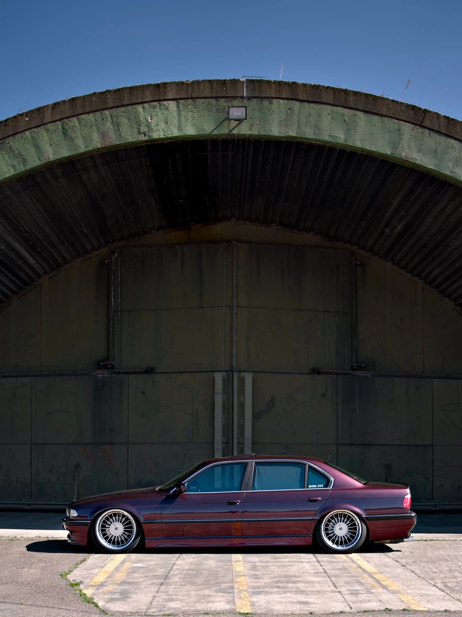 Bordeauxrote Limousine vor einem Hangar